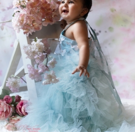 Baby girl in beautiful gown with props